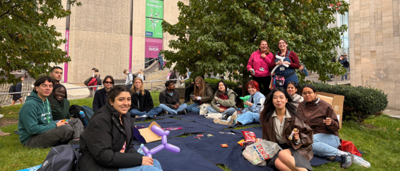 a group of students sitting on picnic blankets outside the Fraser Building
