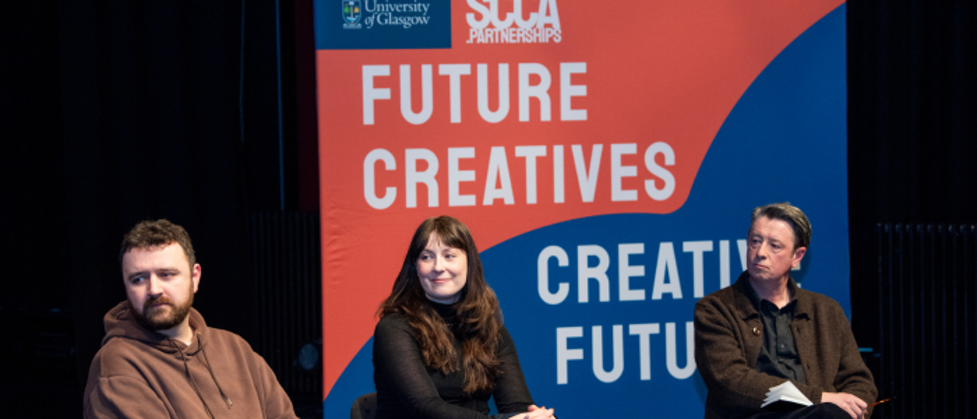 three people sitting in front of a banner with 'FUTURE CREATIVES CREATIVE FUTURES' on an orange and blue background