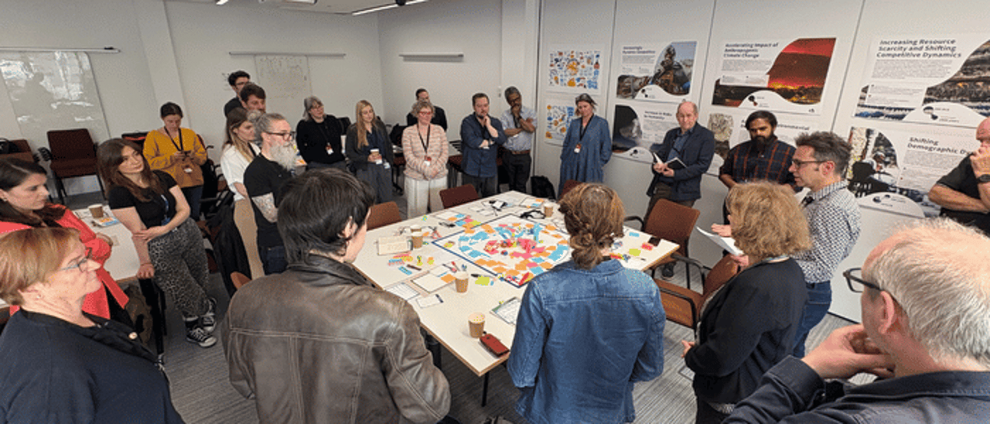 A group of people around a table with various objected lied out on it