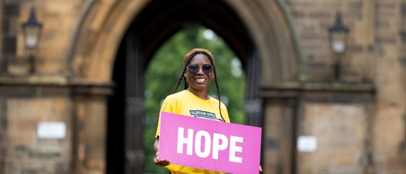student in yellow t-shirt holding banner with hope on it