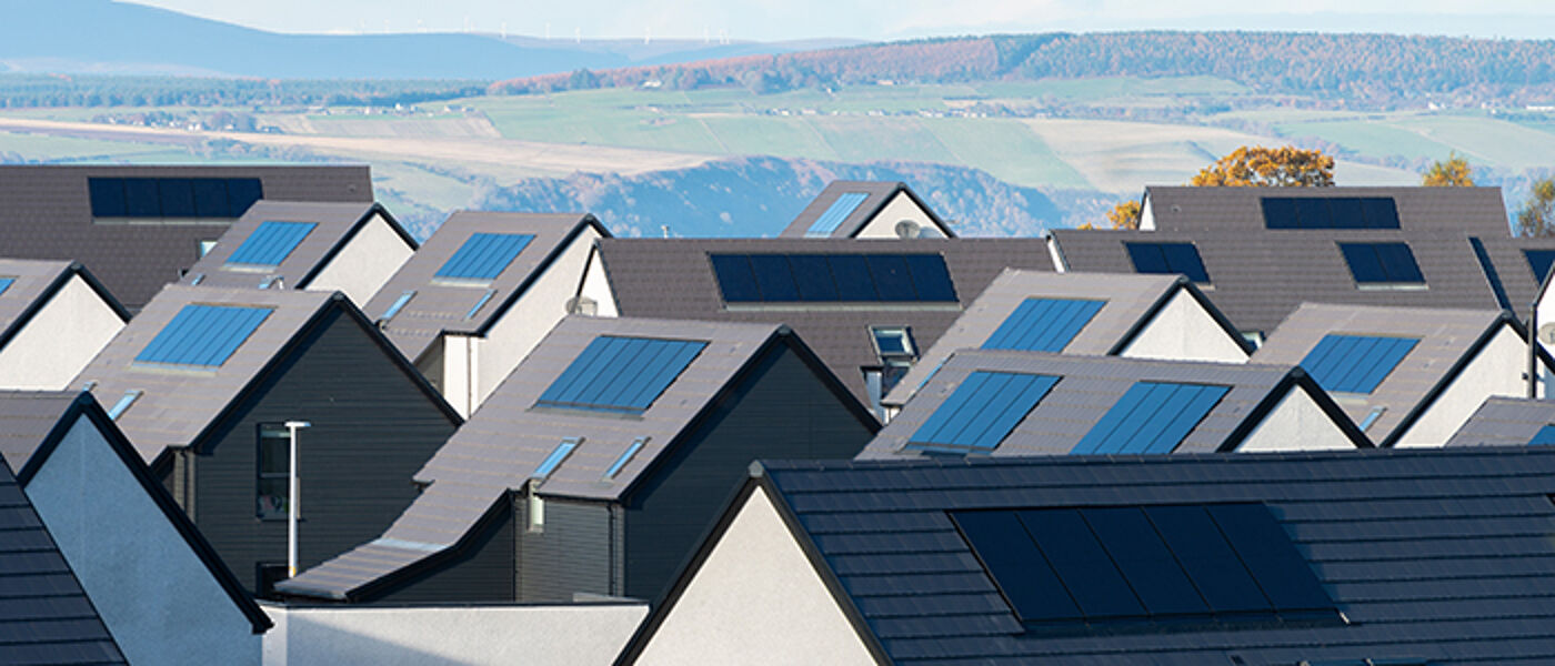 roofs with solar panels, mountains in the background