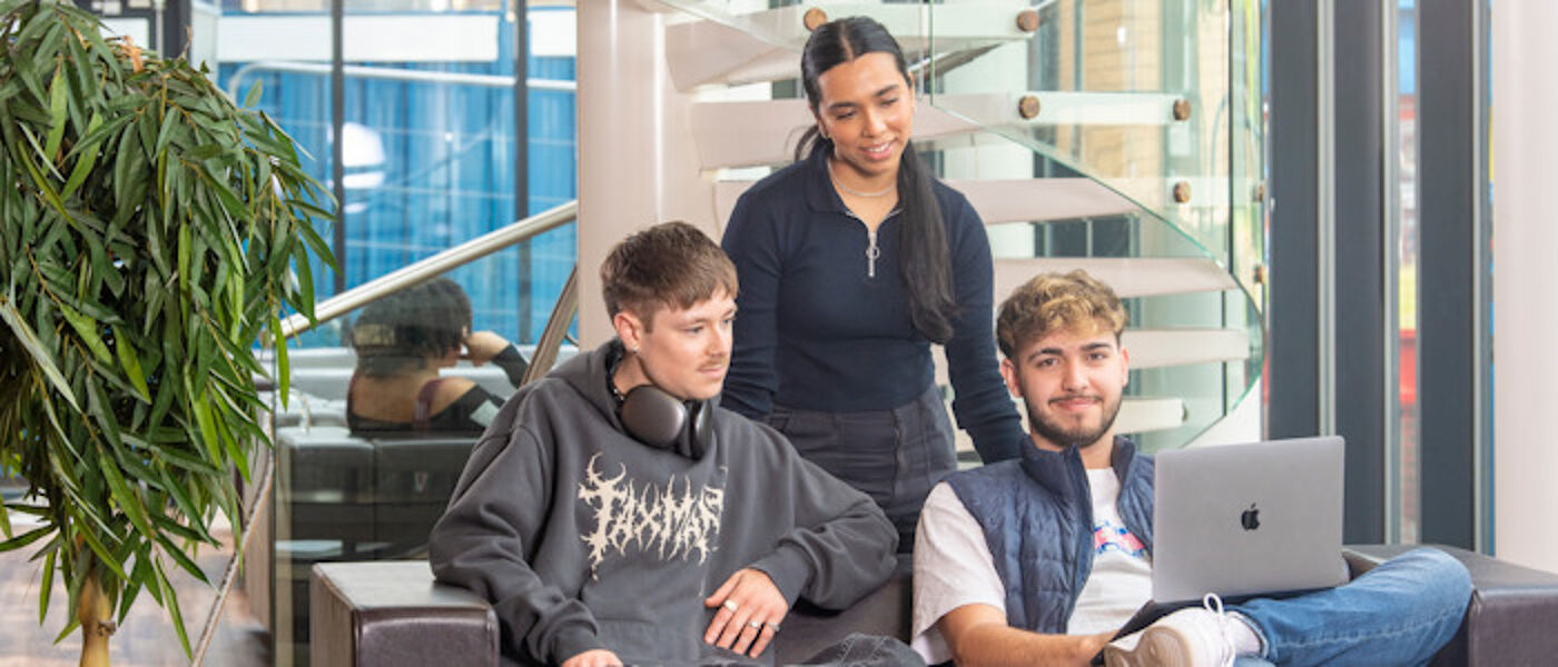 Several students chat in the library while studying