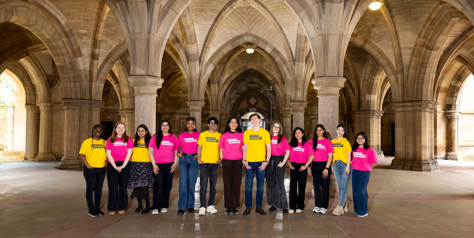 Students in yellow and pink t-shirts in the cloisters