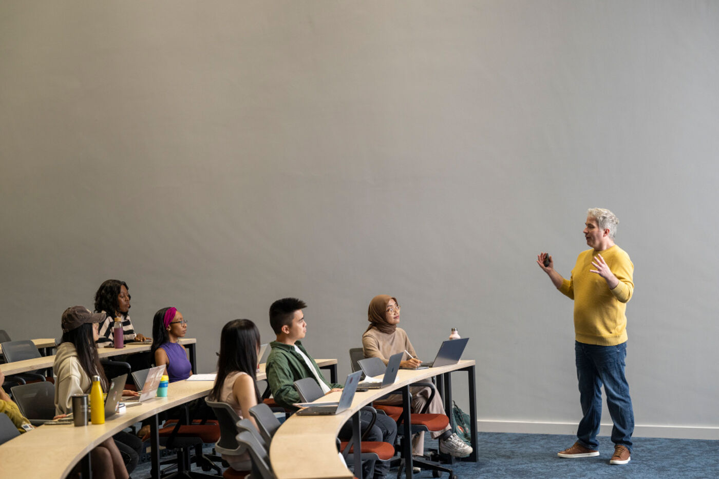 A lecturer standing in front of multiple rows of engaged students.