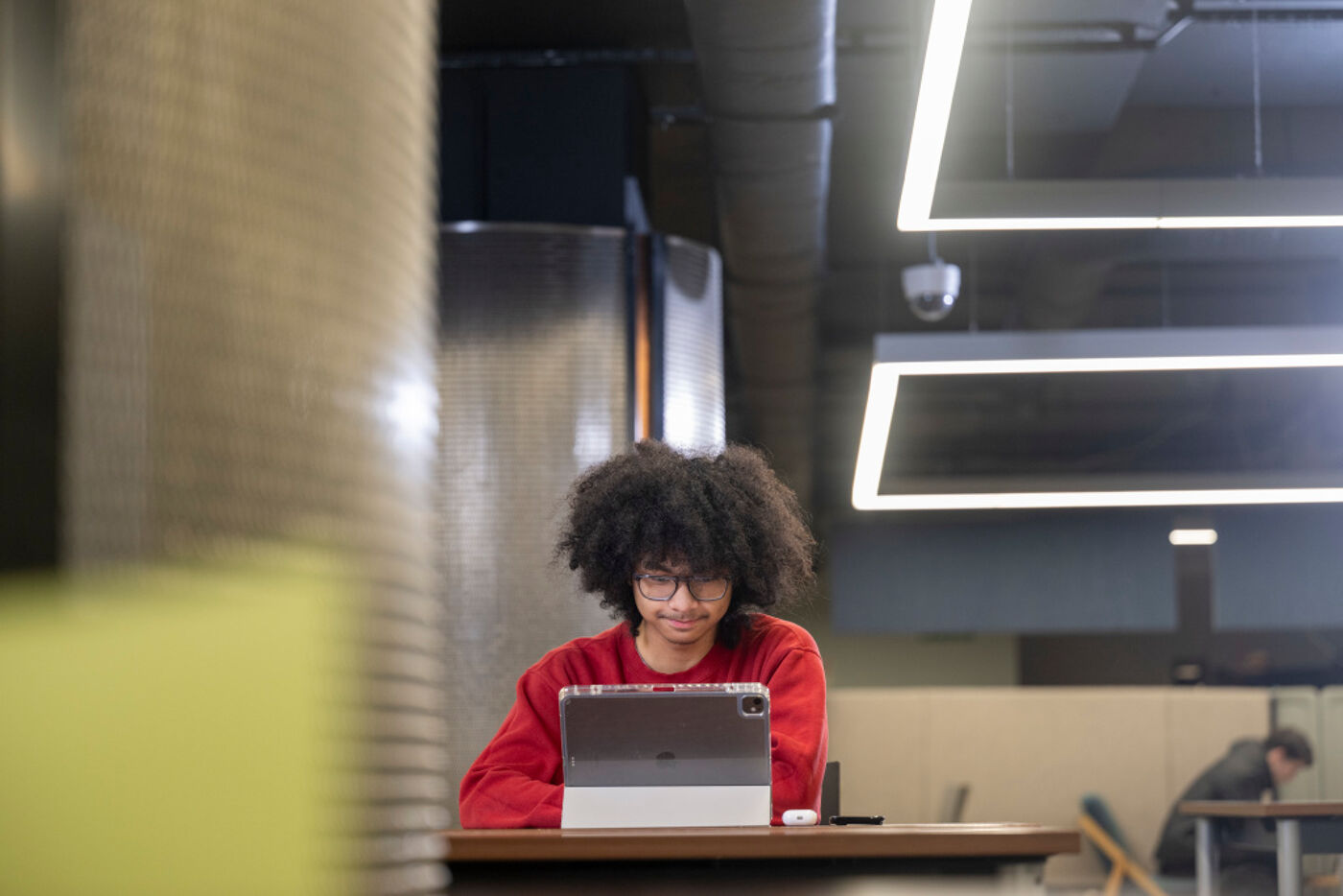 A student sitting in the library looking at their laptop.