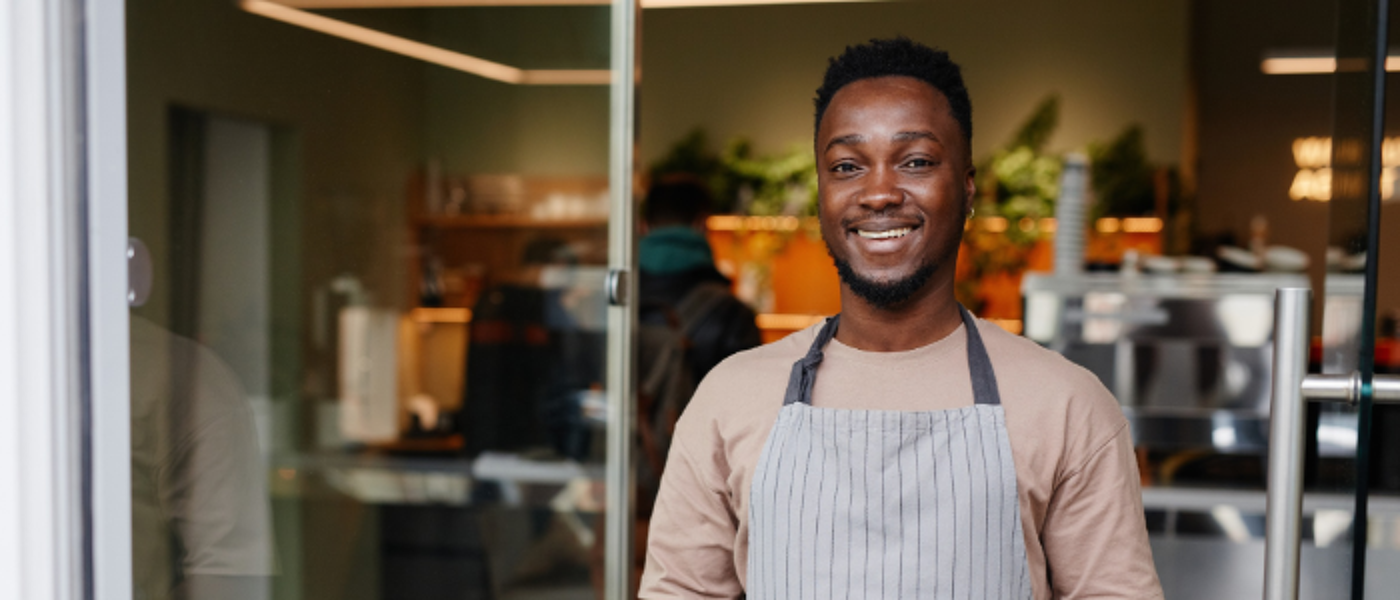 Young man holding tray in front of cafe