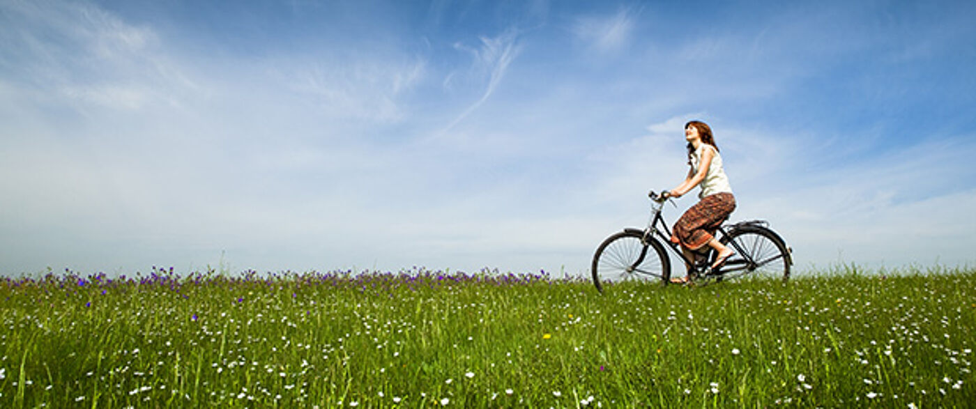 girl cycling in a field