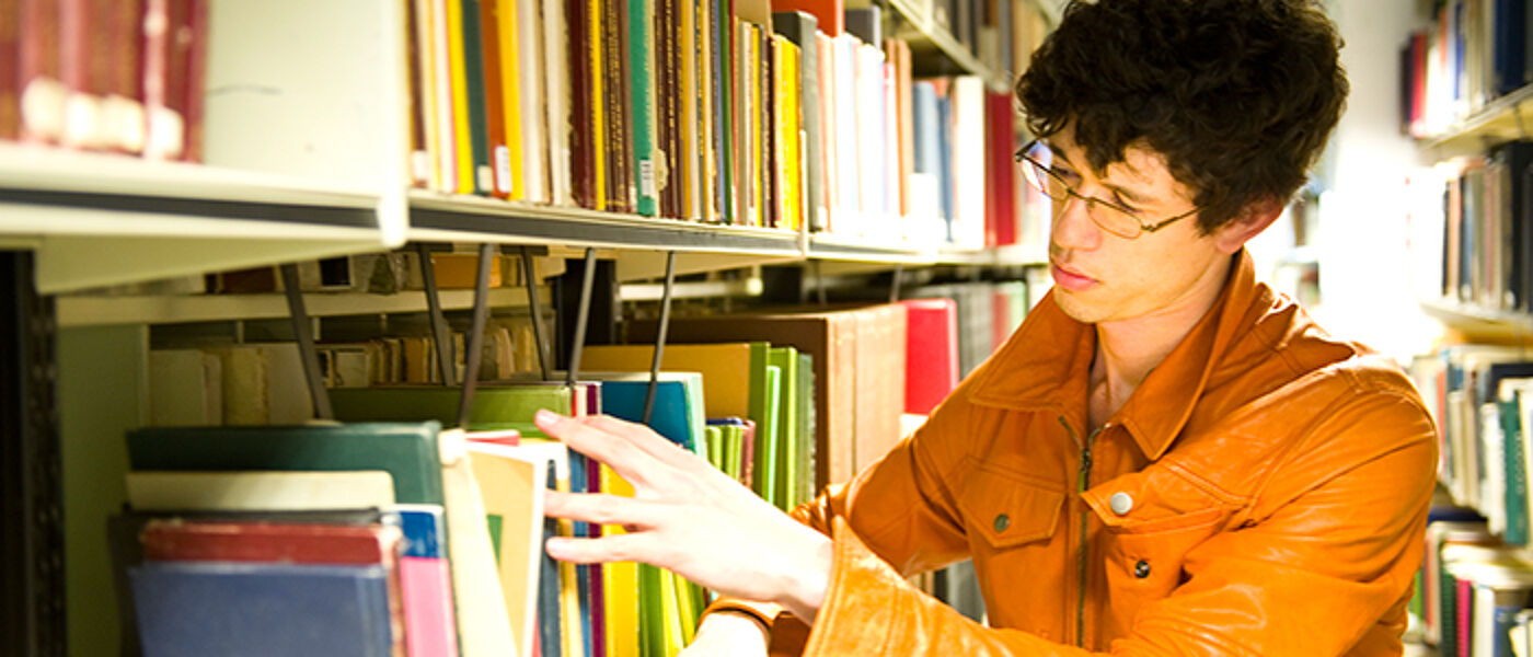 student choosing book in Glasgow University library