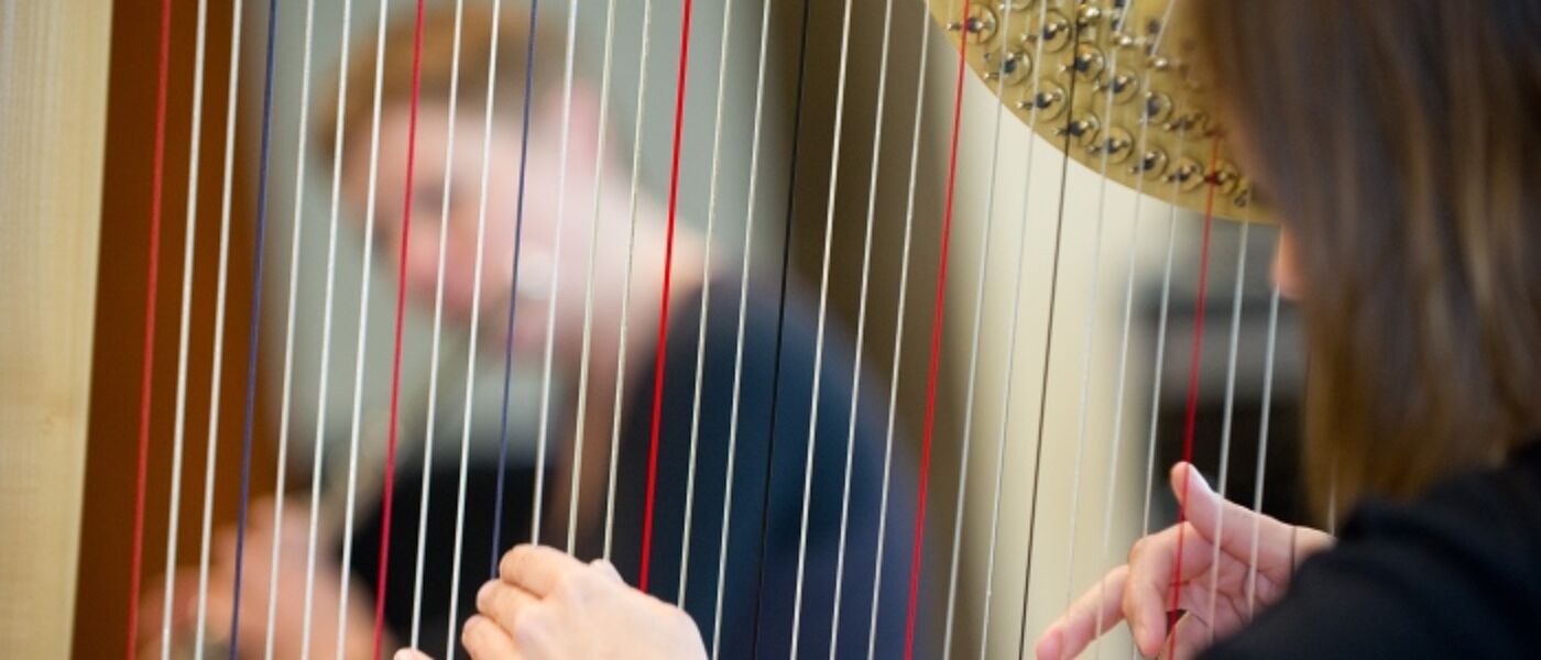 Music student playing harp