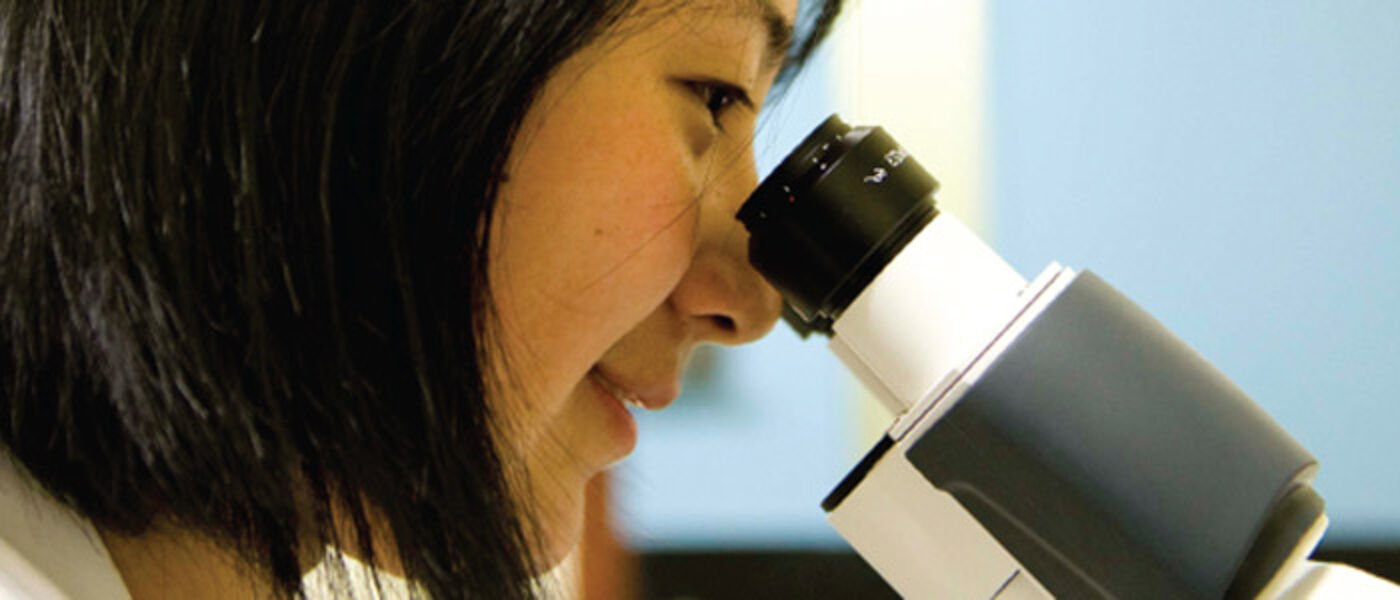 Student looking into microscope