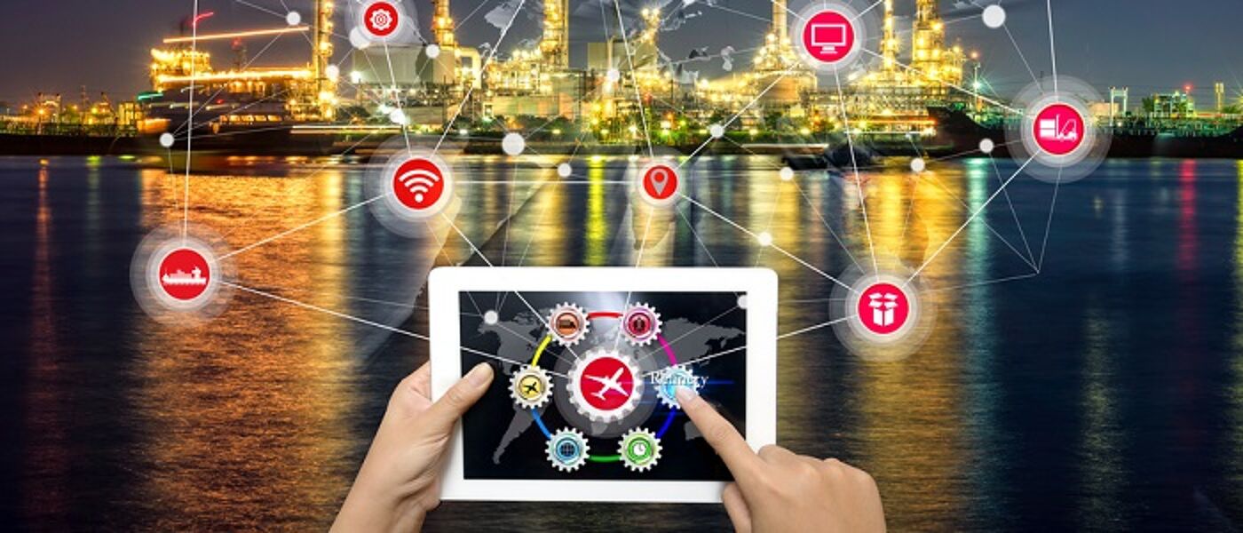 A tablet being held in front of an industrial park 