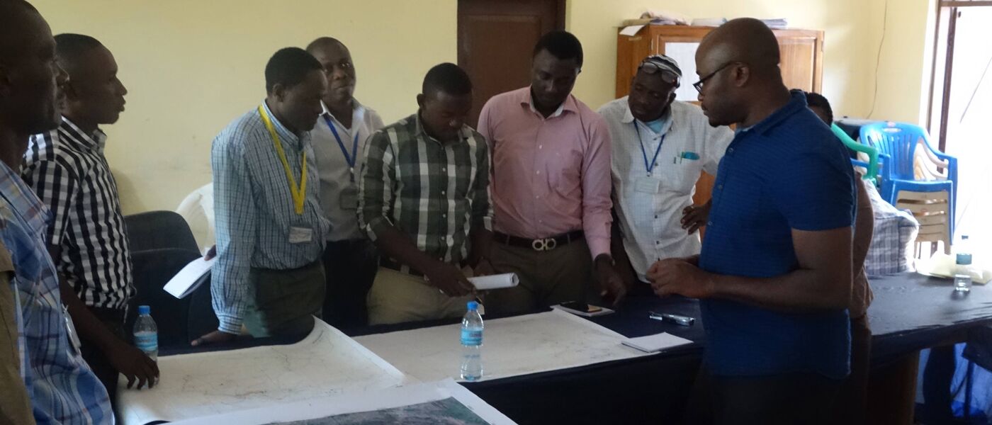 Group of researchers standing around a table working on a foot and mouth disease workshop exercise