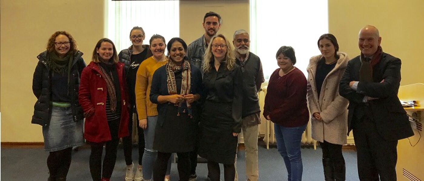 Group of people standing in front of a presentation about Kerala