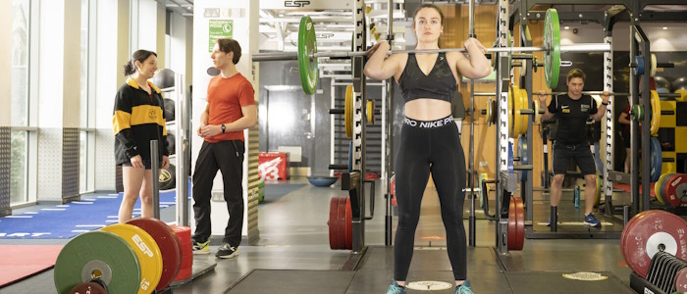 Students lifting weights and exercising in the gym