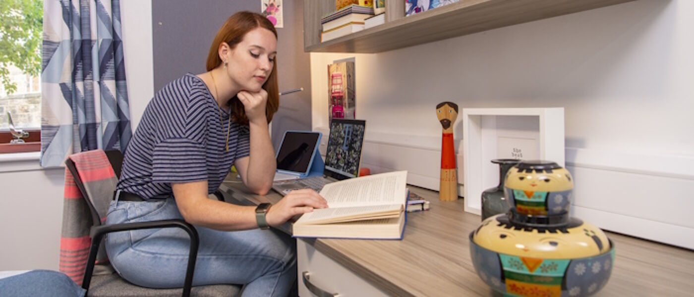 a femal student reading in her room