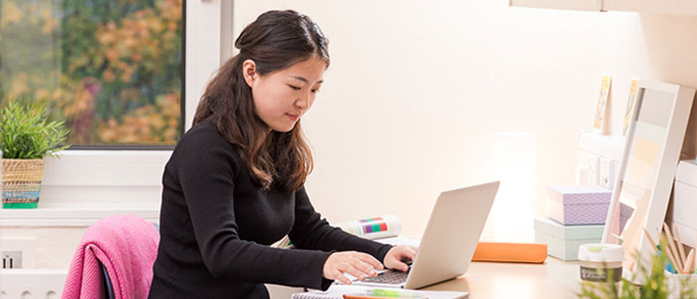 Image of student woking on laptop in accommodation