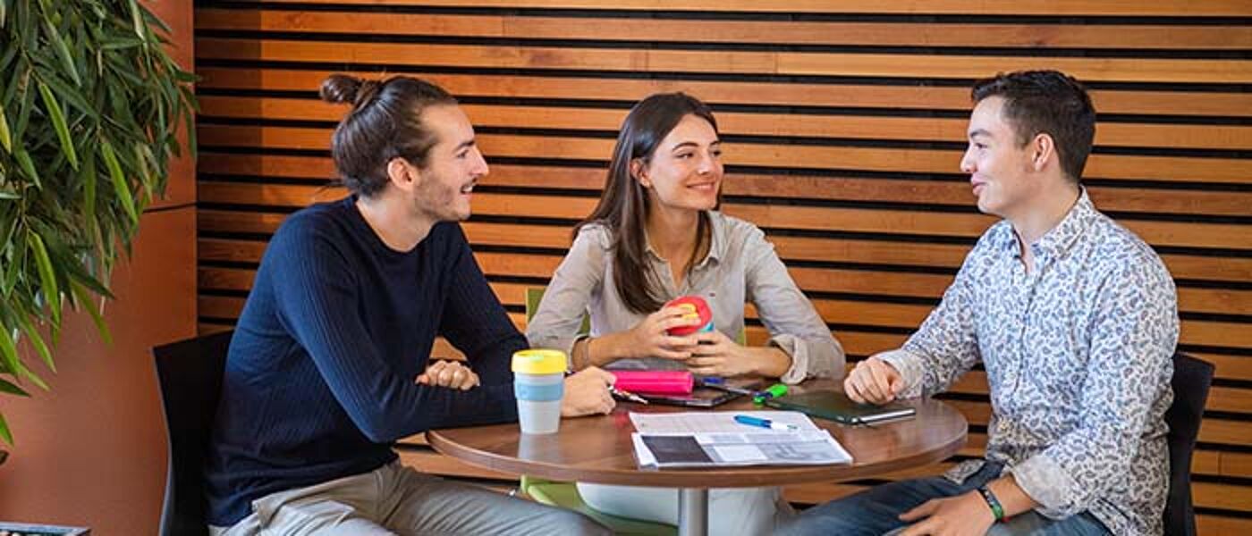 Students talking at a table in the University Library