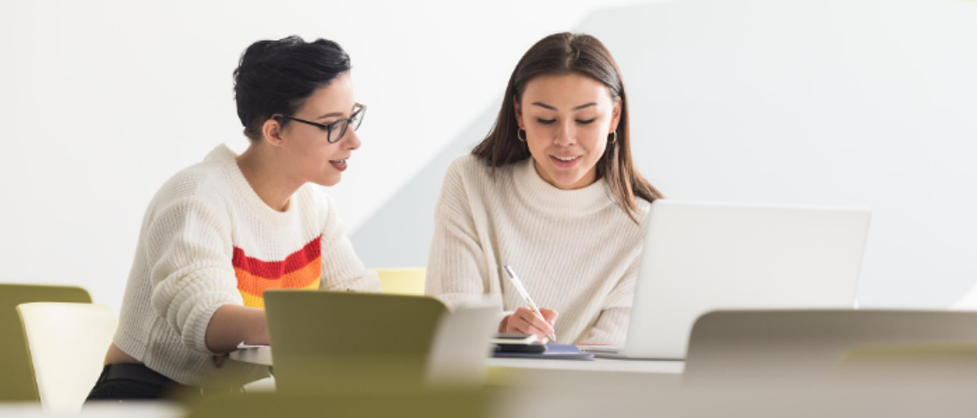 Two students sitting at a table in a lecture