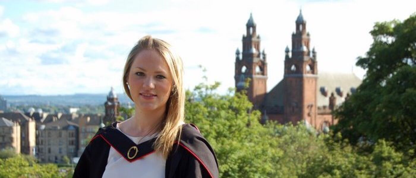 Female graduate in front of museum towers