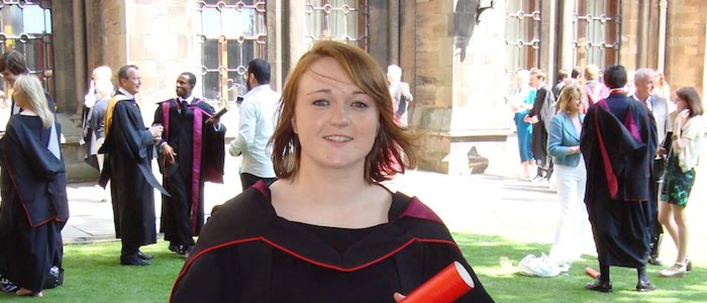 Female graduate in the quad