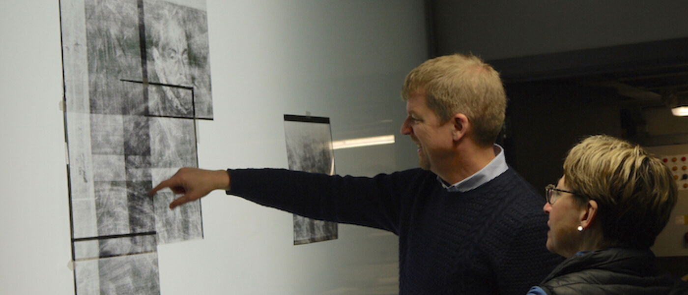 Researchers discussing an x-ray of a painting
