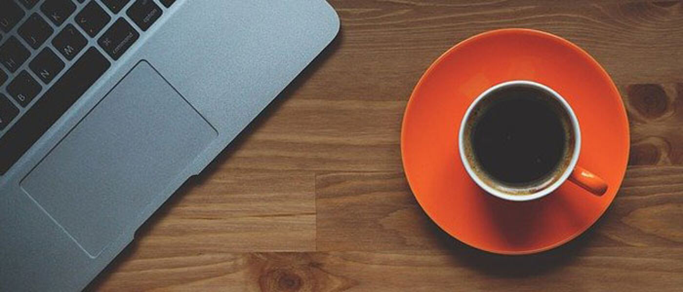 Laptop and cup of coffee on a desk