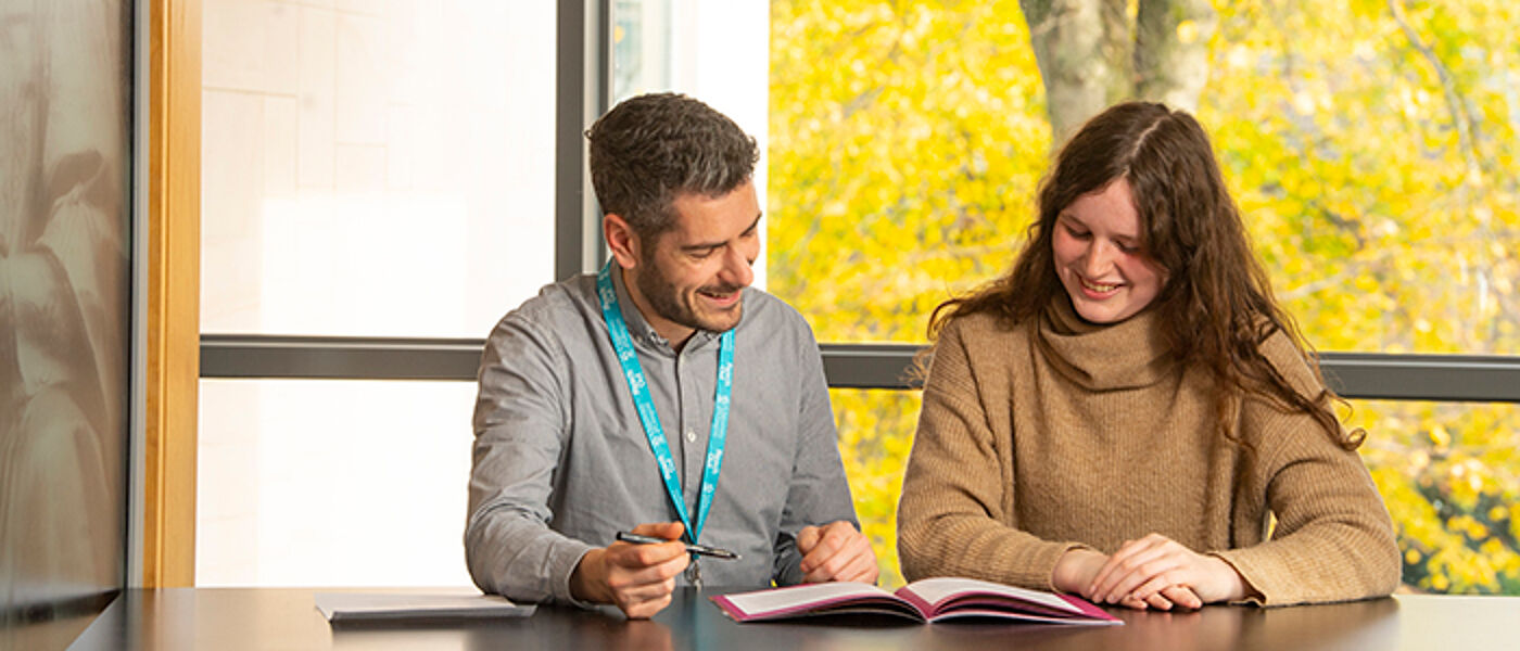 An undergraduate student talks to a member of staff at Student Services