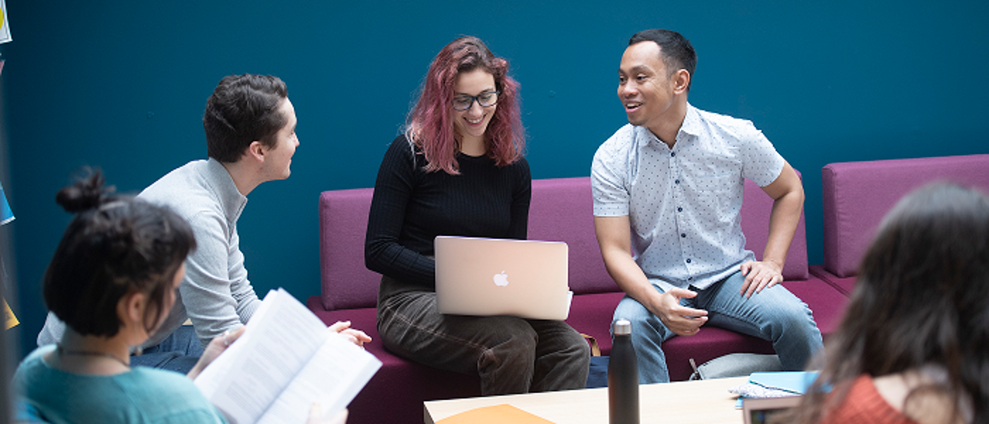 Dumfries study group against a blue wall 