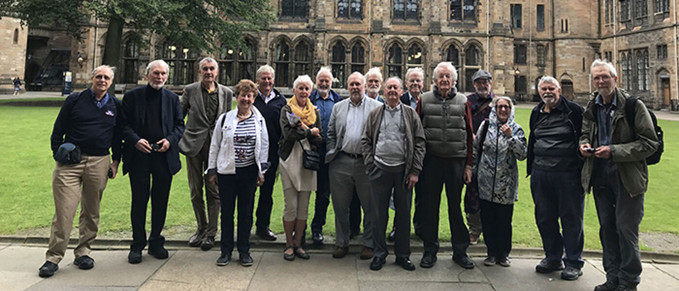 A group of alumni standing outside the west quad at a reunion on campus