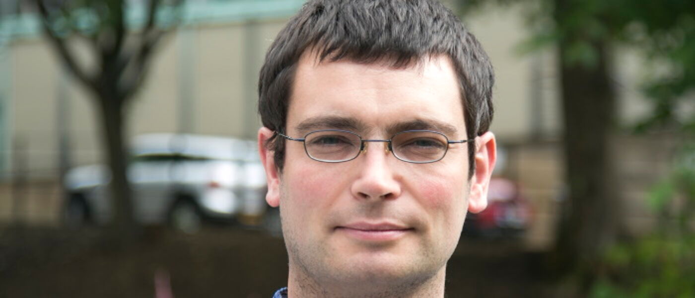Dr Iain Martin head shot with outdoor background.