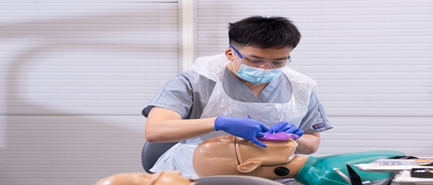 Student placing rubber dam