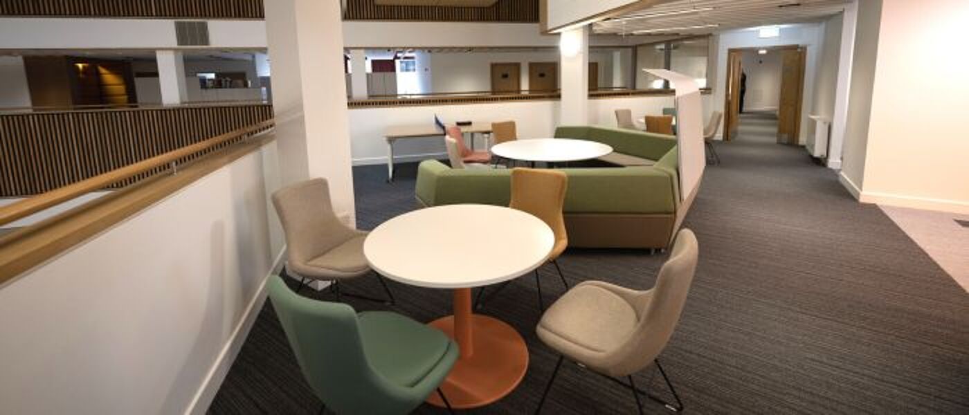 Relaxed meeting space with round tables and comfy chairs