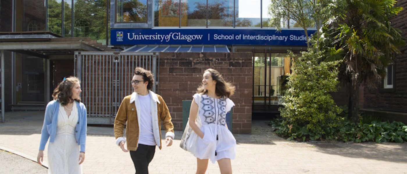 students in Dumfries campus around a large boulder