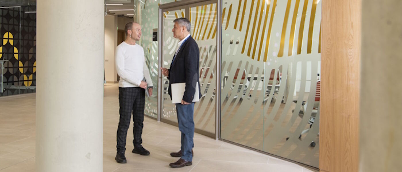 2 staff members standing talking