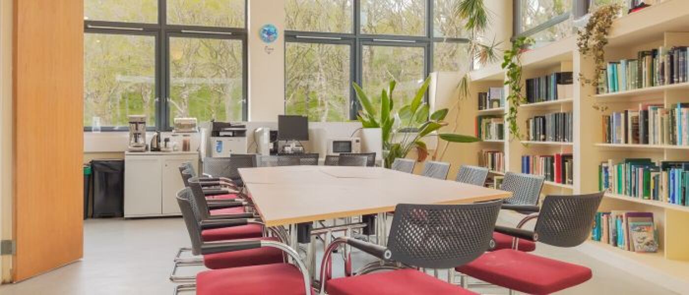 The Maitiland common room with bookcases, comfy chairs, refrigerator and table