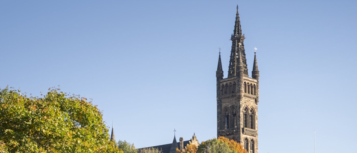 University of Glasgow main building tower, tree tops and blue sky
